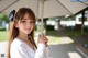 A young woman holding an umbrella in a park.