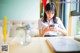 A woman sitting at a table looking at her phone.