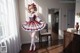 A woman in a red and white dress standing in a room.