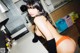 A woman in a cat ears outfit is posing in a kitchen.